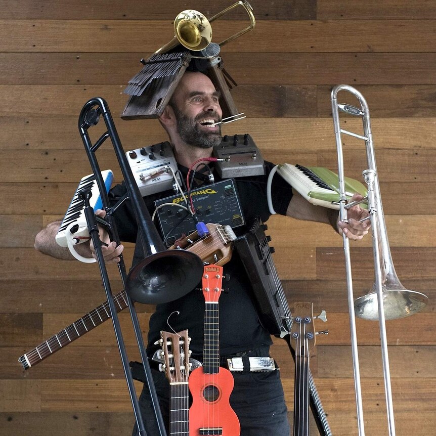 Mal Webb wearing a bunch of instruments and audio gear like clothing.