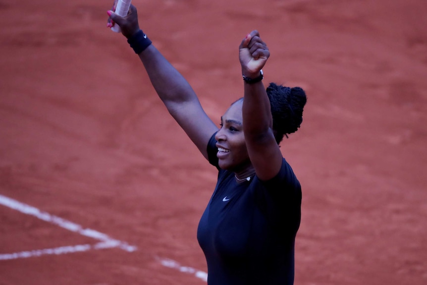 Serena Williams pumps the air after winning on clay court