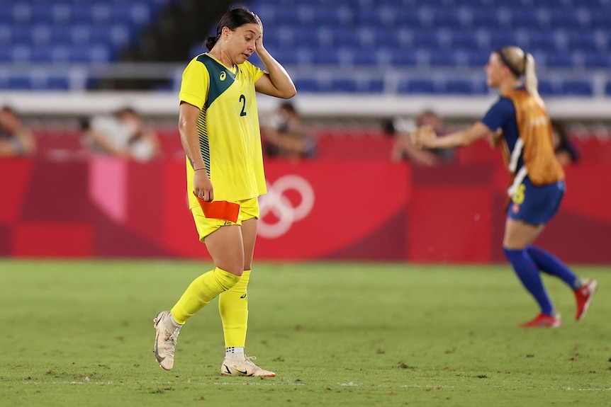 Sam Kerr puts her head in her hand and loots shattered.