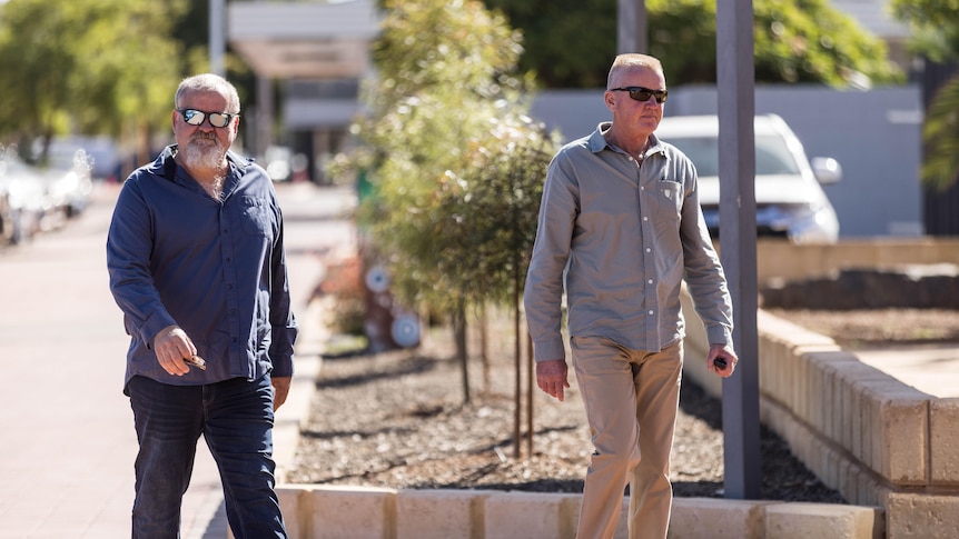 Two men walking into a police station.