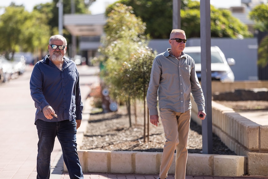 Two men walking into a police station.