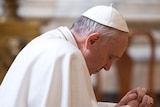 Pope Francis kneels to pray