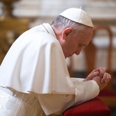 Pope Francis kneels to pray