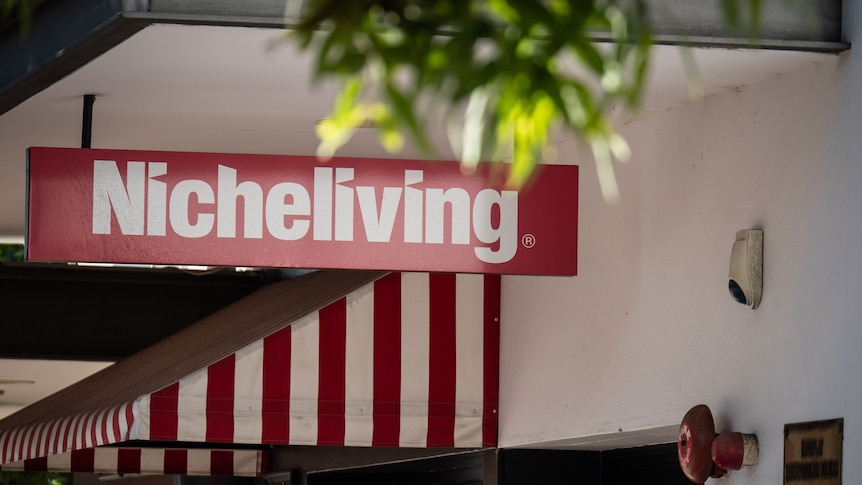 Office building entrance with sign saying Niche Living and glass doors