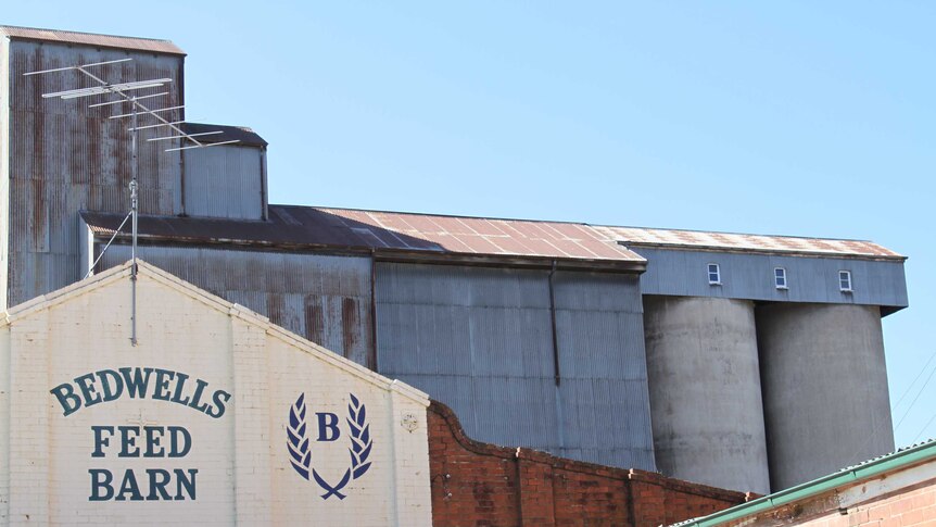 An external shot of a mill, with brick and corrugated iron buildings.