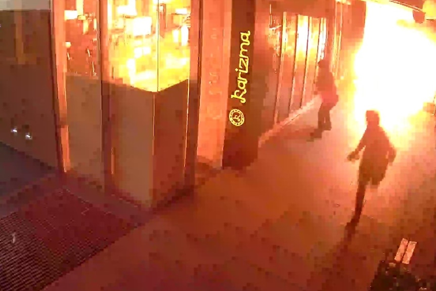 Two men outside a burning building.