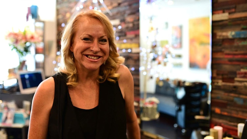 Adult hairdressing apprentice Veronica Ford smiles in her workplace, a hair salon in Brisbane.