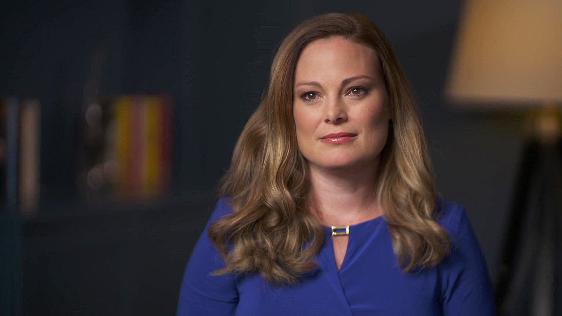 A woman wearing a blue top.