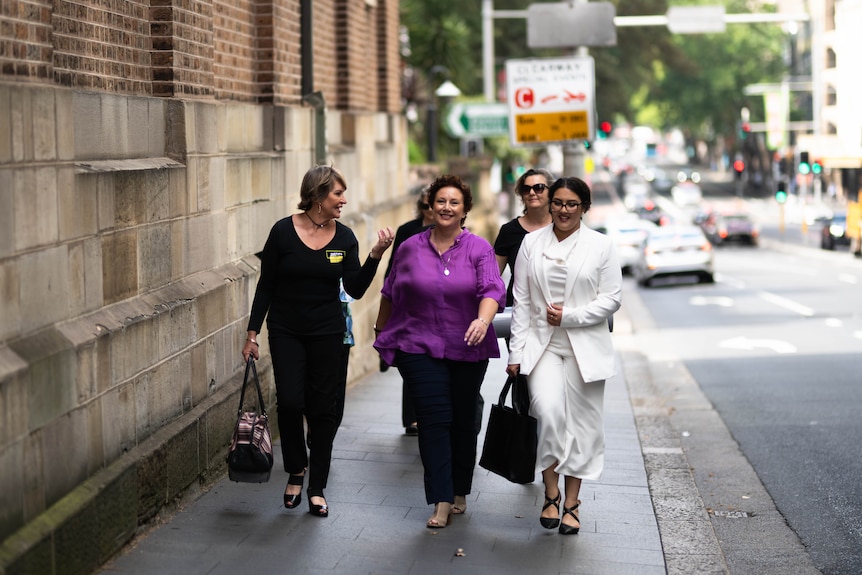 Three women walking near a court