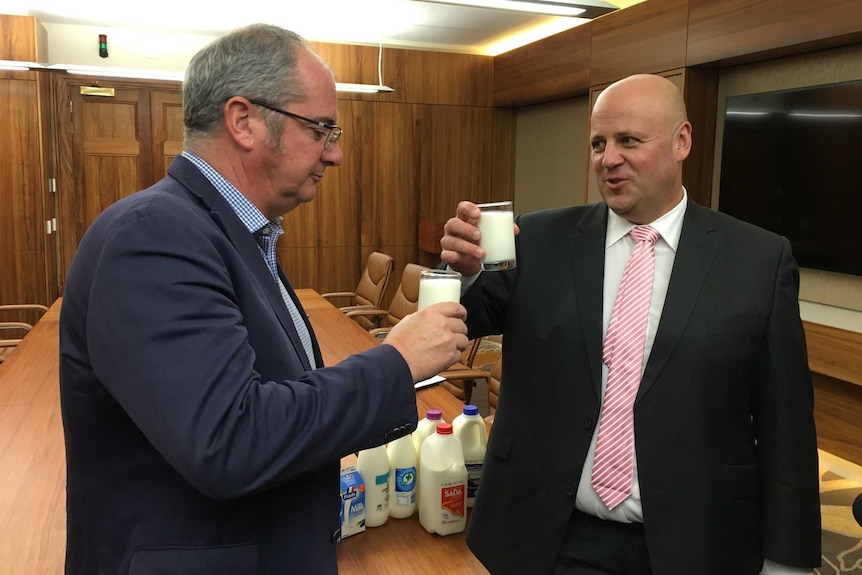 Agriculture Minister Leon Bignell and SA Dairyfarmers' Association president David Basham drink glasses of milk