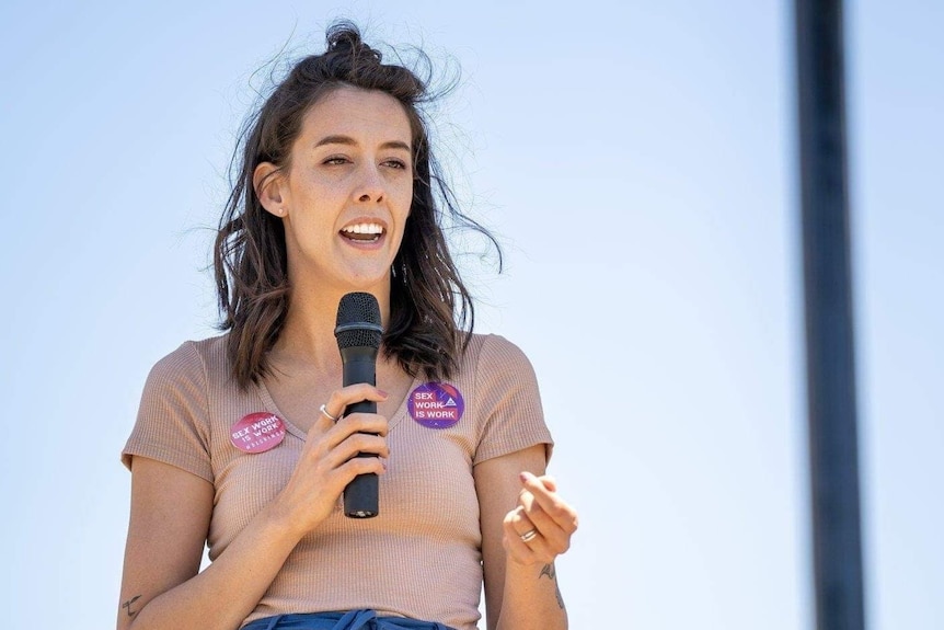 A woman with brown hair holding a microphone