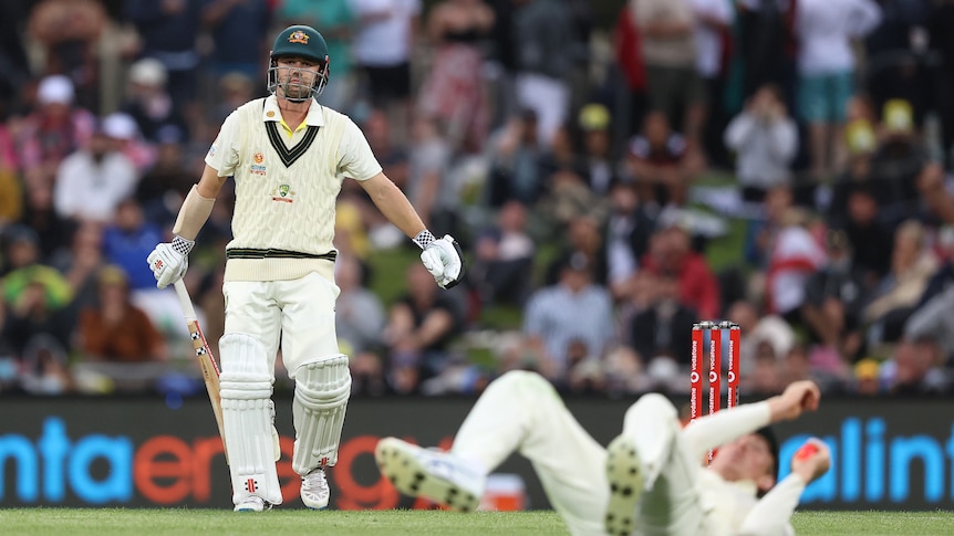 Australia batter Travis Head watches as his cricket shot goes away from him. An English fielder is on the ground.