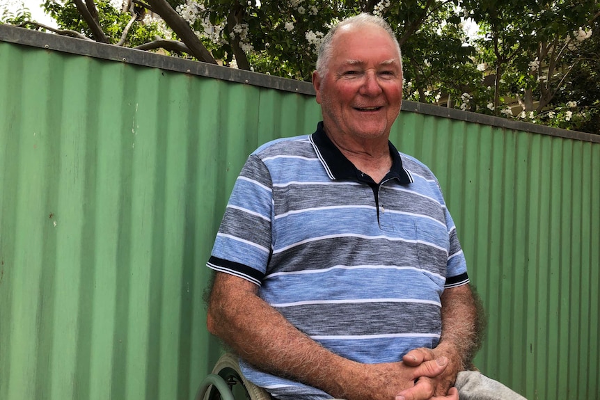 A man sits in his garden in a wheelchair