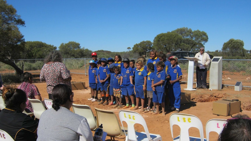 A group of school children and elders gather at Mt Margaret mission for the repatriation of Aboriginal remains.