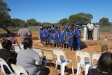 A group of school children and elders gather at Mt Margaret mission for the repatriation of Aboriginal remains.