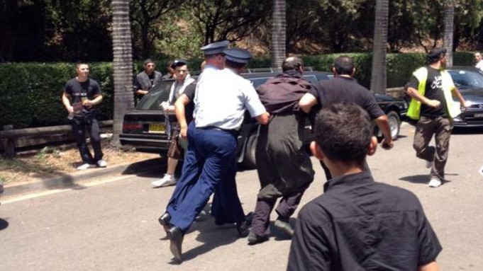 Police restrain one of two men who were arrested after an incident at Arncliffe Mosque.