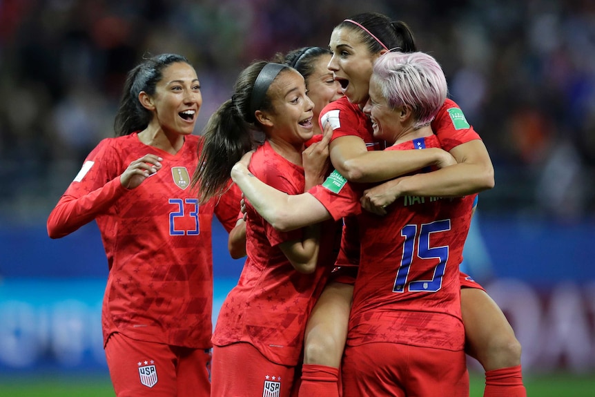 Alex Morgan is surrounded by her teammates