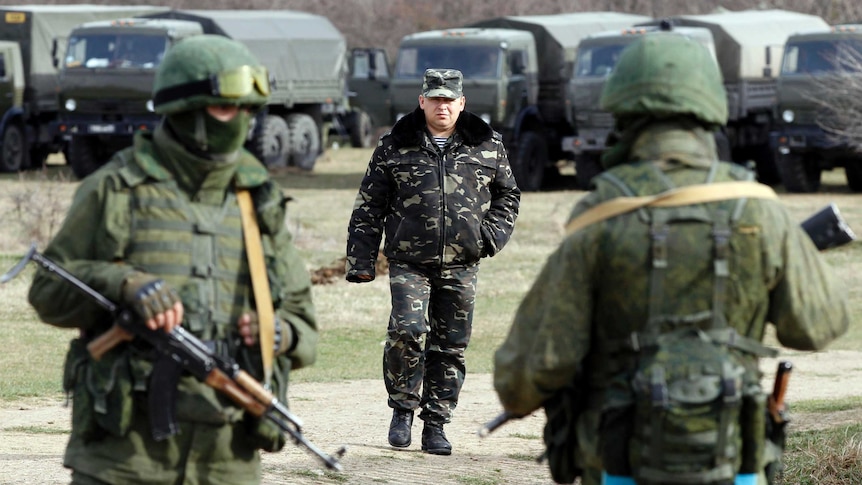 Ukraine military officer approaches troops in Crimea.
