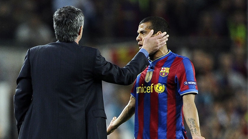 Better luck next year: Inter boss Jose Mourinho gets touchy with Barca's Dani Alves.