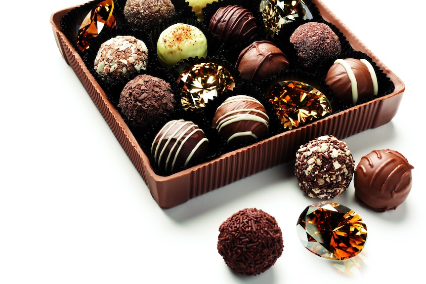 A box of chocolate truffles with brown diamonds standing in for some of the chocs.
