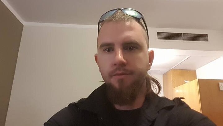 A selfie of a man with a mullet wearing a black jacket.