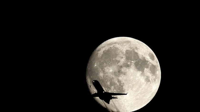 A plane flies past the full moon over Budapest September 25, 2007