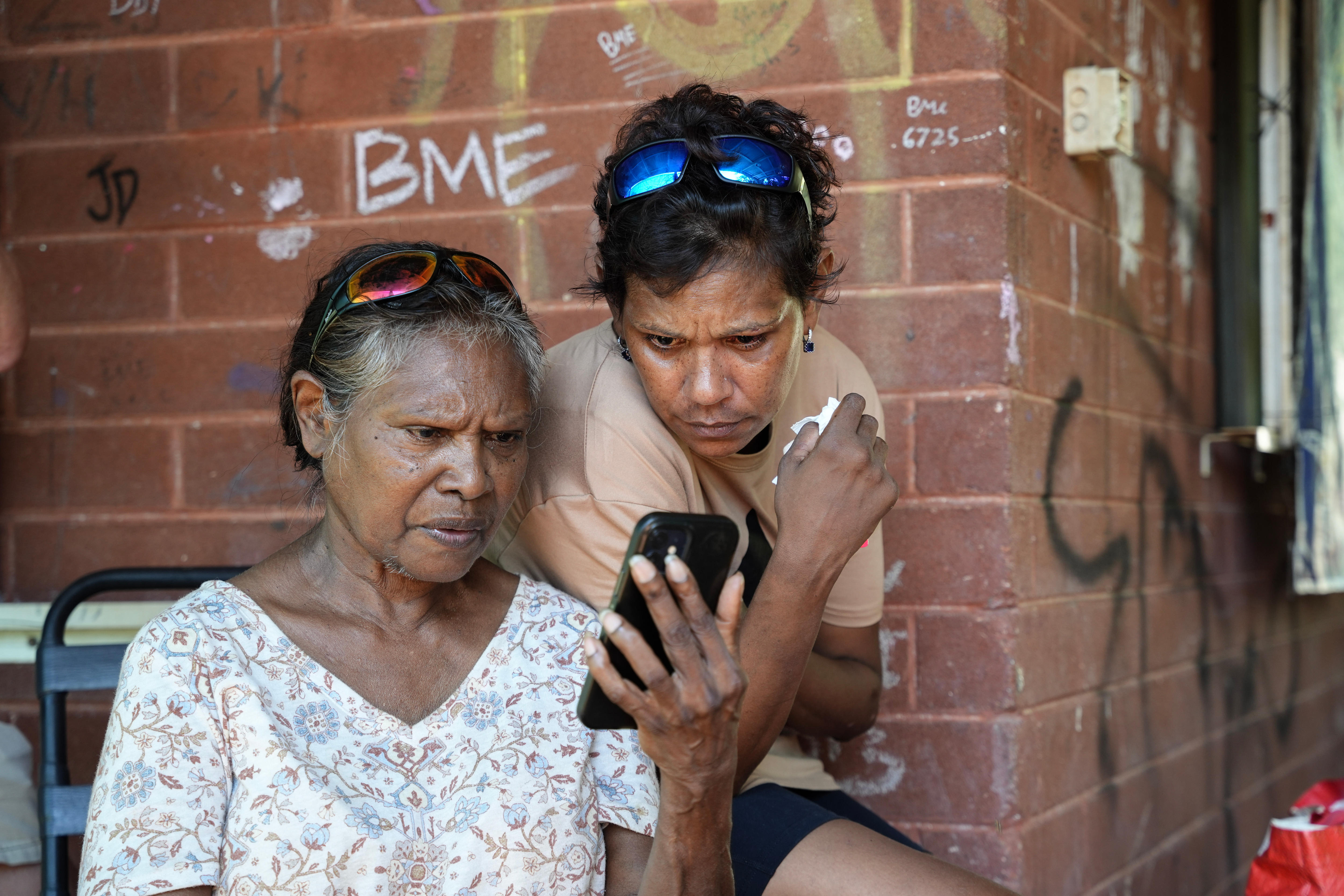 Dos mujeres miran un teléfono 