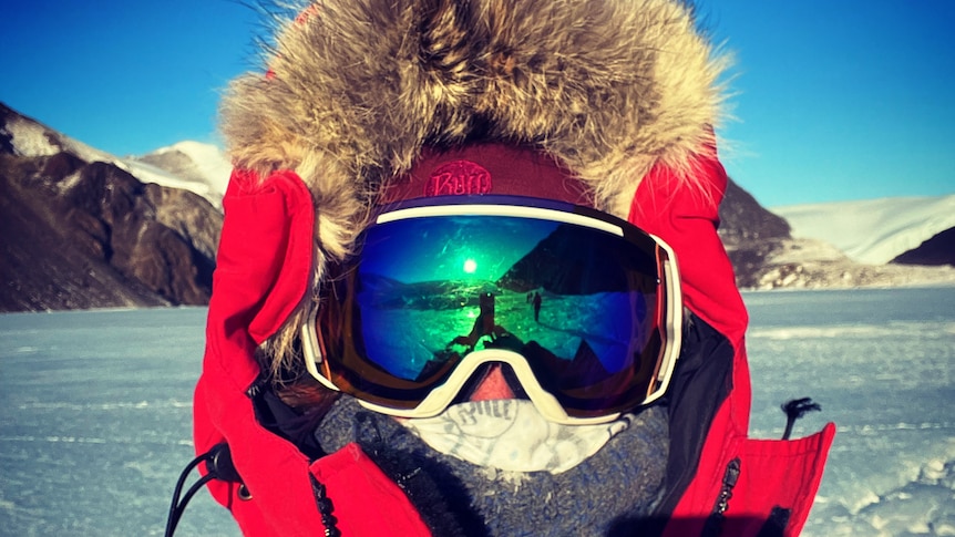 Rebecca Jeffcoat wearing goggles and sub-zero protective clothing in Antarctic landscape.