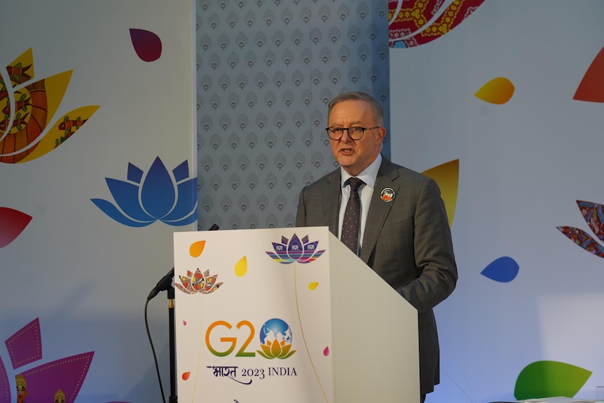 Anthony Albanese stands behind a podium that says G20.