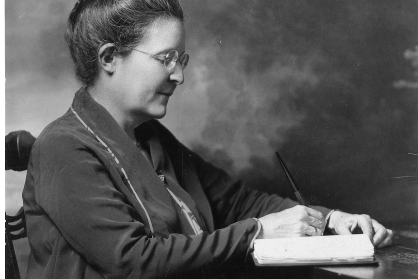 A vintage photo of a woman writing a letter