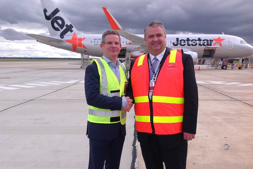 Jetstar chief executive officer David Hall and Justin Giddings from Avalon Airport shake hands on the deal.