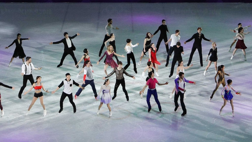 A group of ice skaters perform together at the Winter Olympics.