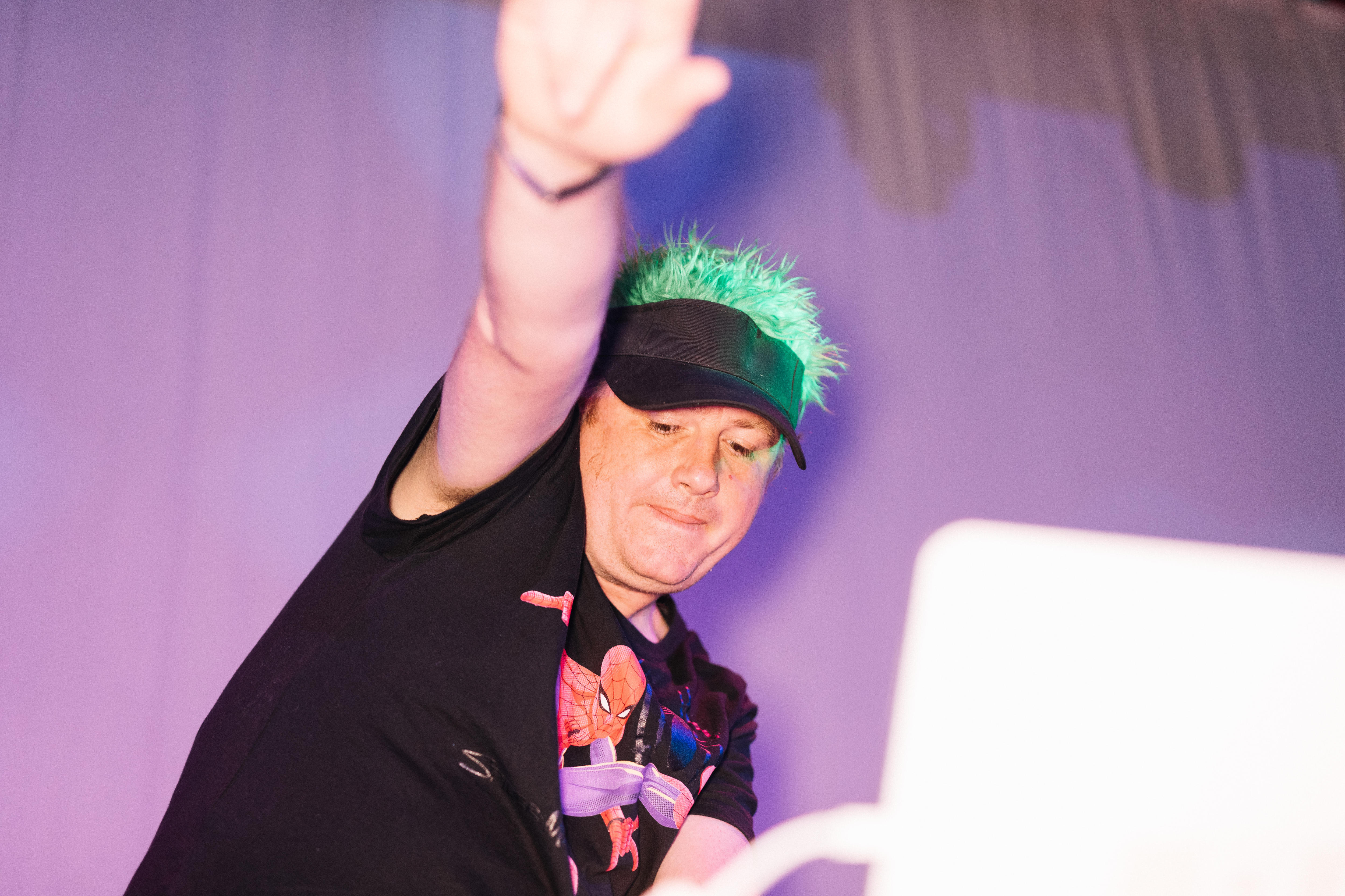 James Bull with his hand in the air as he does a DJ set