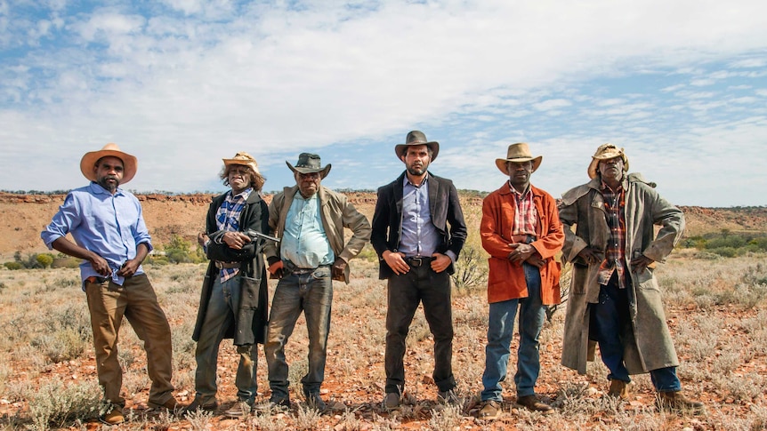 Actors in the film Never Stop Riding stand in a line.