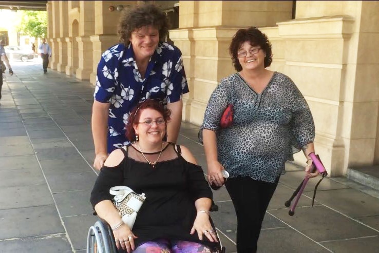 Antonia Fleming in a wheelchair with her supporters outside court