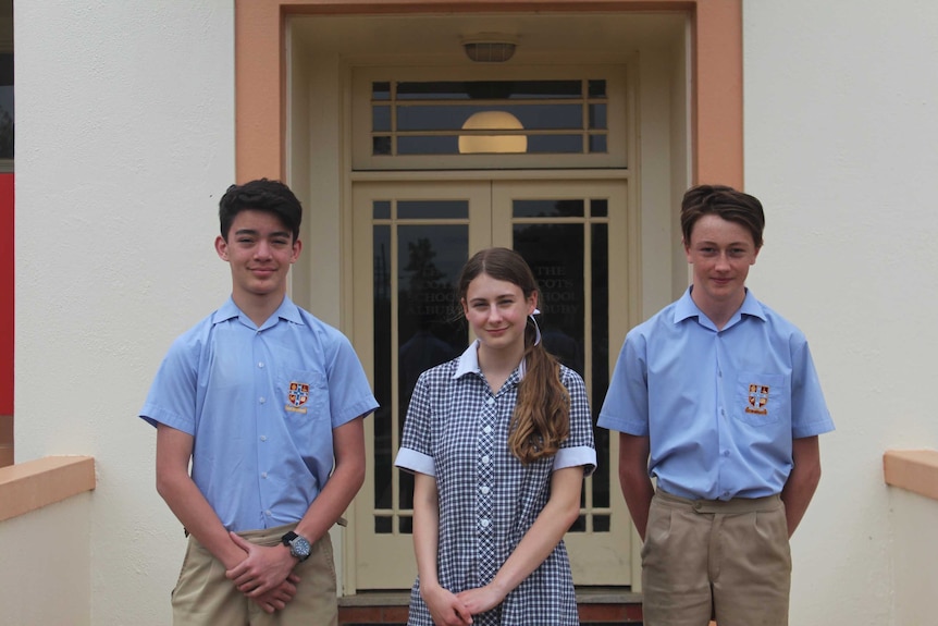 Two boys and a girl, school students of the Scots School Albury smiling in uniform