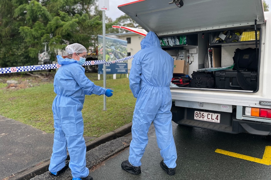 Two officers in forensic overalls