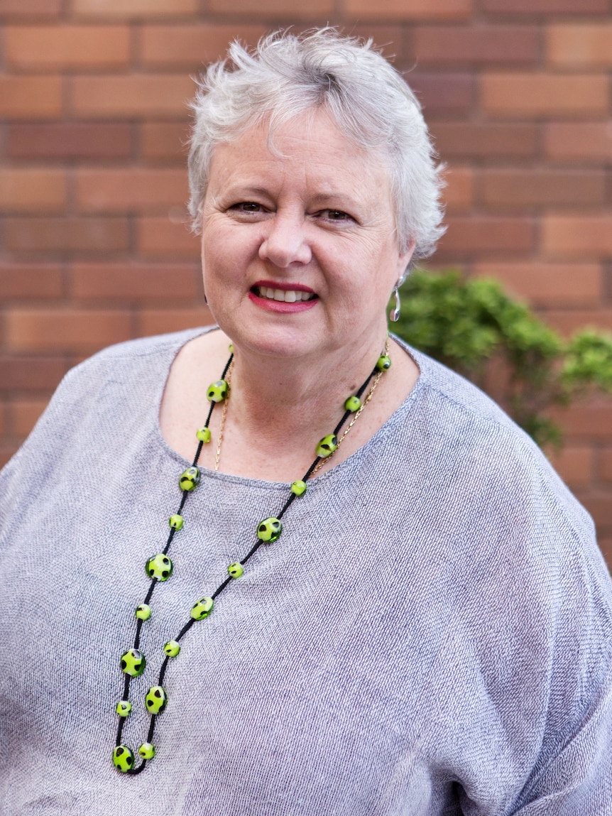 Portrait of a woman with grey hair and a purple shirt