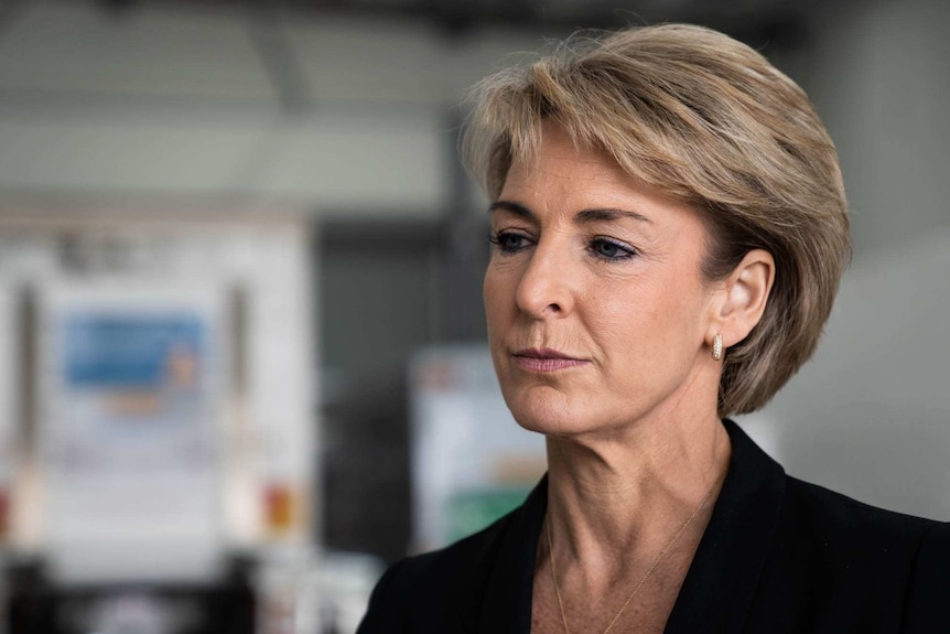 Michaelia Cash wearing a black jacket in a school classroom.