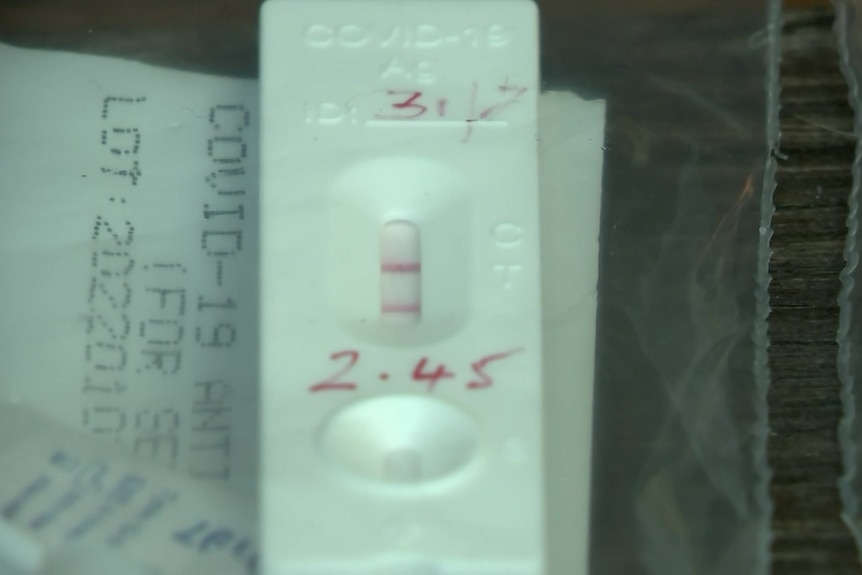A close-up on a positive rapid antigen test.