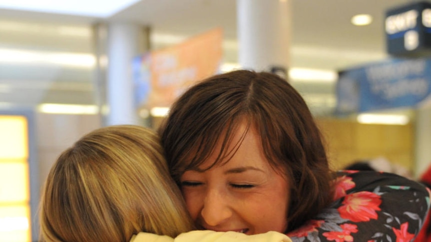 Michelle Byrne (R) is welcomed home by her mother Jill at Sydney International Airport.