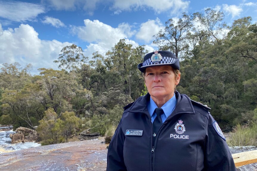 Great Southern Police District Superintendent Kim Travers standing on bridge over rapids in the bush. 