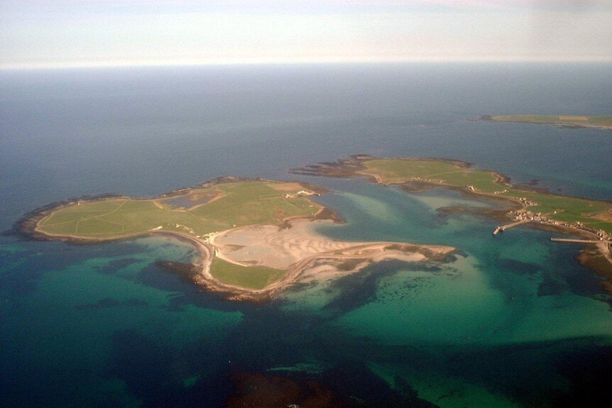 An aerial shot of a three Scottish islands, taken on a clear day.