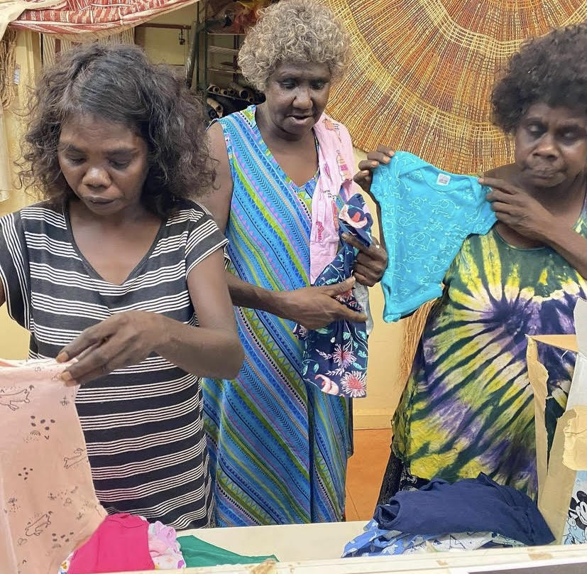 An image of First Nations women in Ramingining unpacking boxes of baby clothes