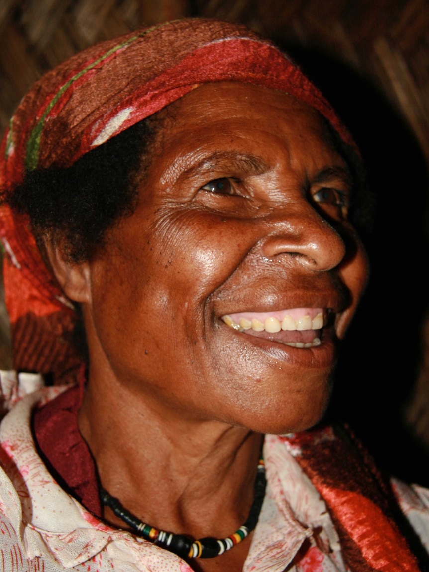 An older Papua New Guinean woman smiling.