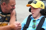 A man talks to a boy in a wheelchair