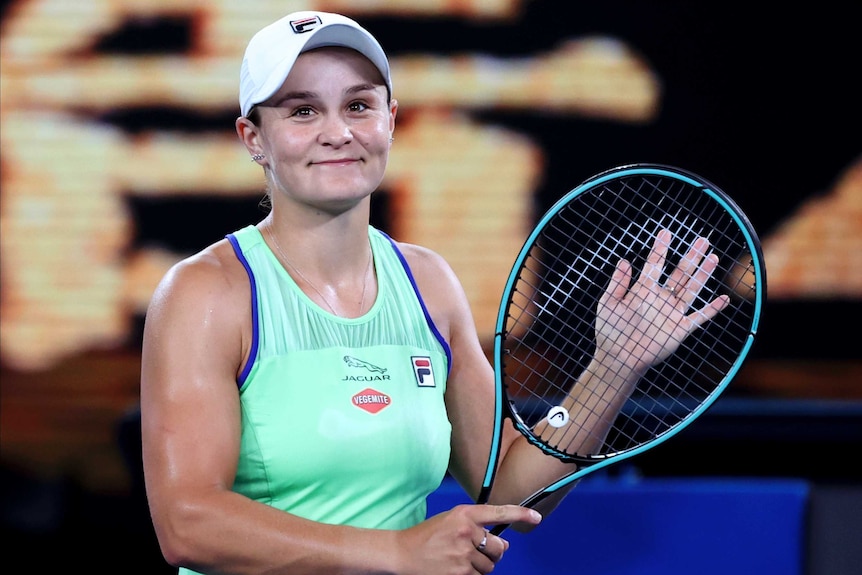 A female tennis player smiles as she claps her racquet to thank the Rod Laver Arena crowd at the Australian Open.