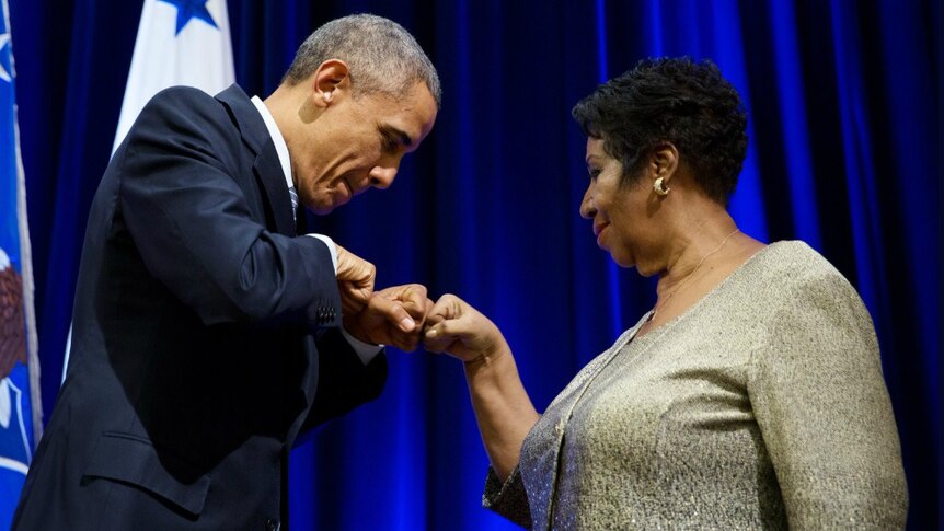 Barack Obama bumps fists with Aretha Franklin.