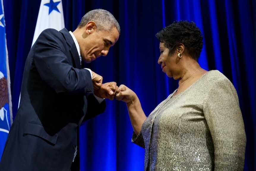 Barack Obama bumps fists with Aretha Franklin.