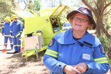 Community Fire Unit volunteer Anne Goyne in front of a firefighting trailer.